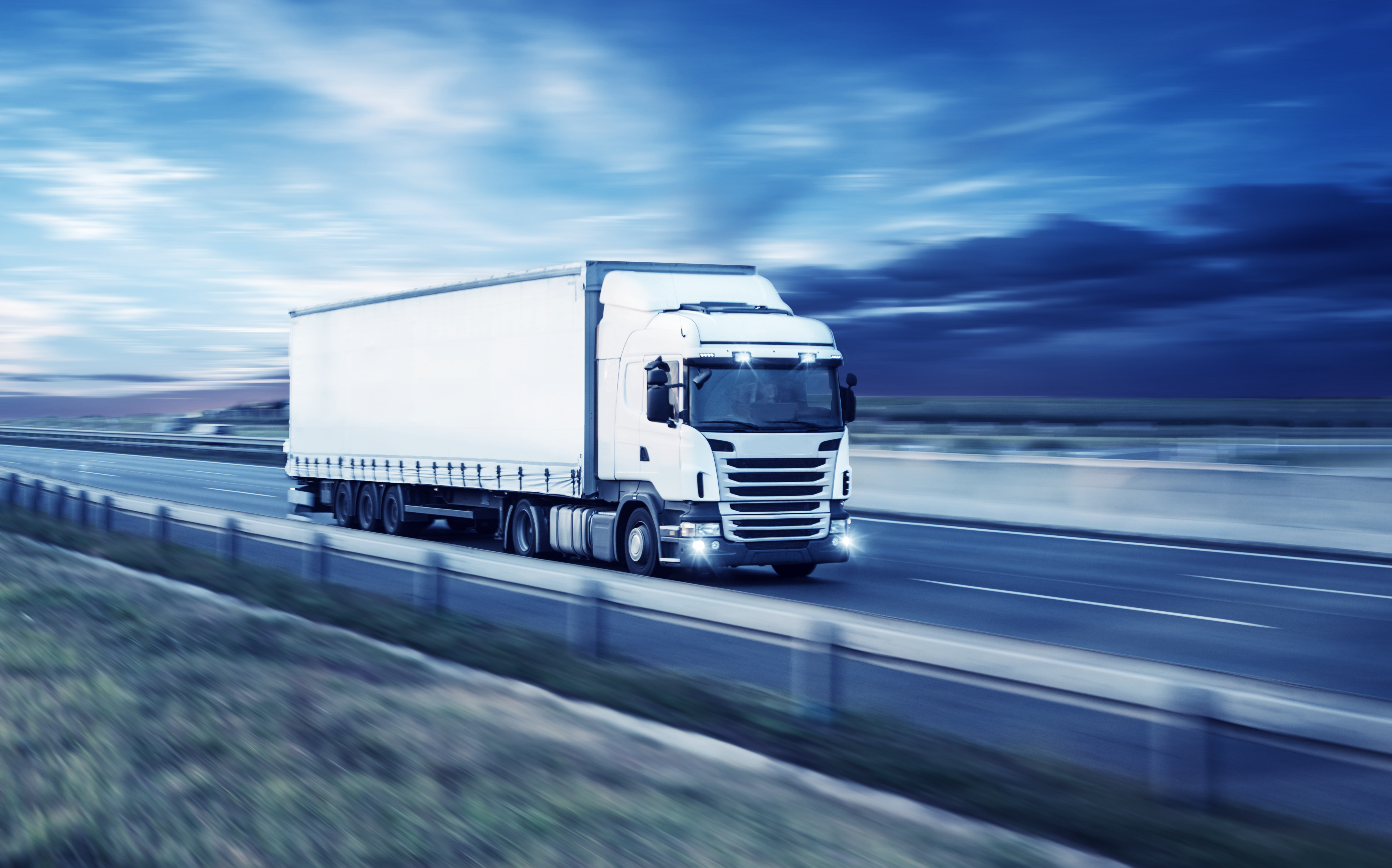 White HGV driving on a motorway.